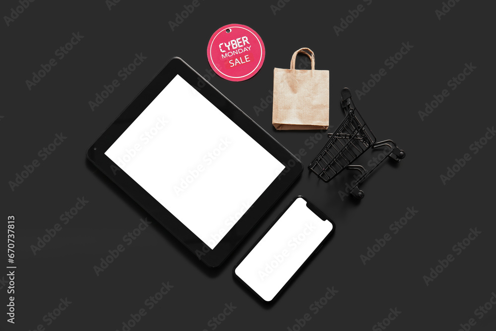 Modern gadgets and tag with text CYBER MONDAY SALE on black background