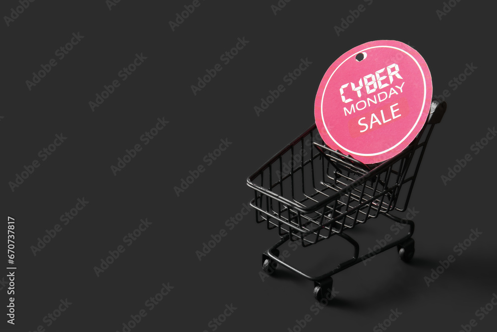 Small shopping cart and tag with text CYBER MONDAY SALE on dark background