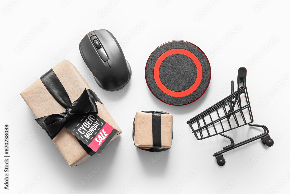 Composition with gift boxes, gadgets and small shopping cart on light background. Cyber Monday sale