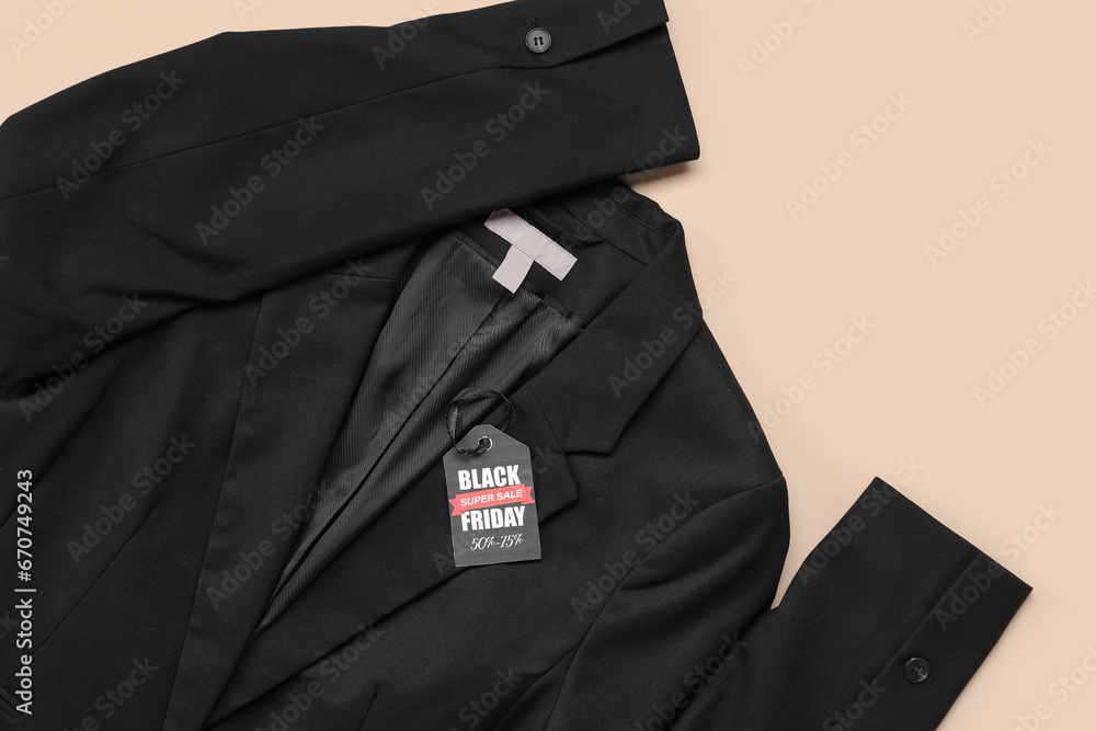 Stylish female jacket and tag with text BLACK FRIDAY SALE on color background, closeup