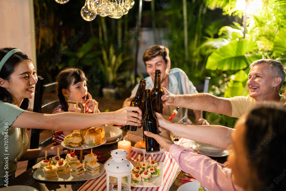 Multi-ethnic big family having fun, enjoy party outdoors in the garden.