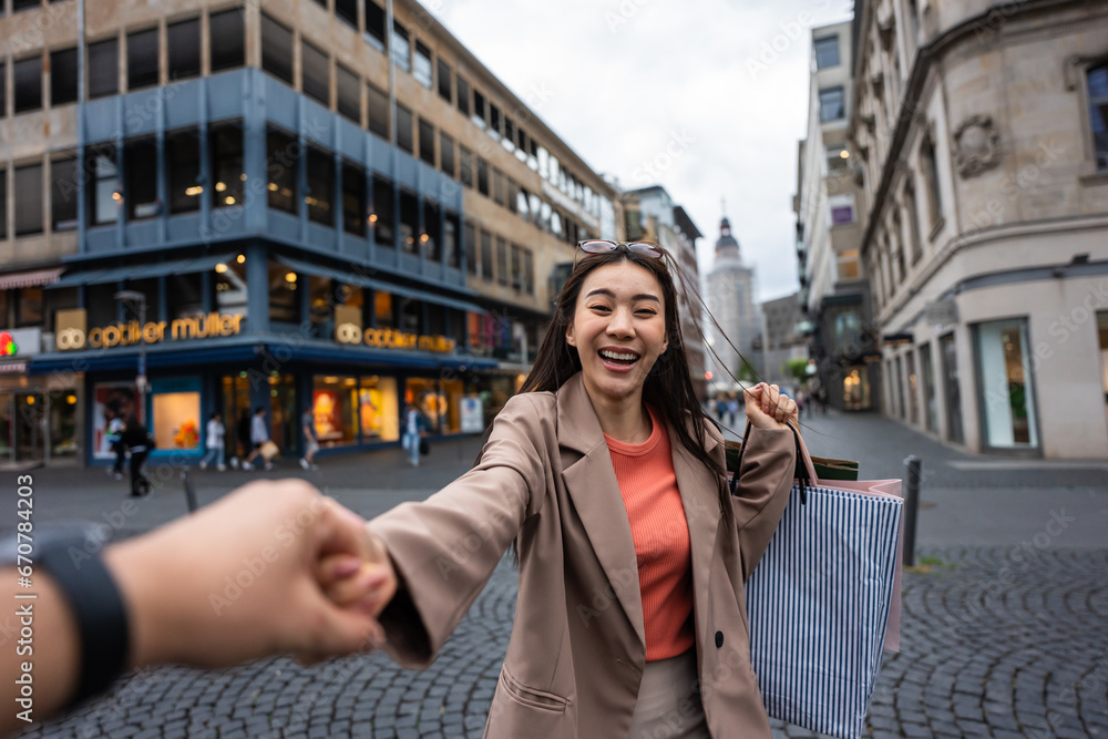 Asian young man and woman shopping goods outdoors in department store. 