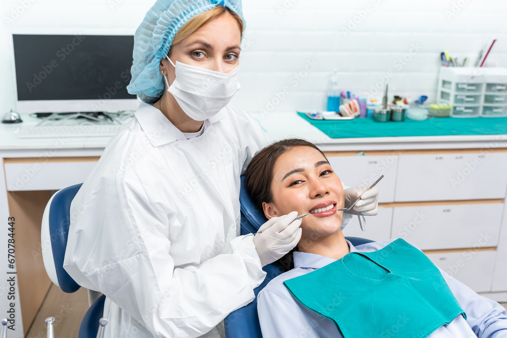 Portrait of Asian young woman patient and dentist at health care clinic. 