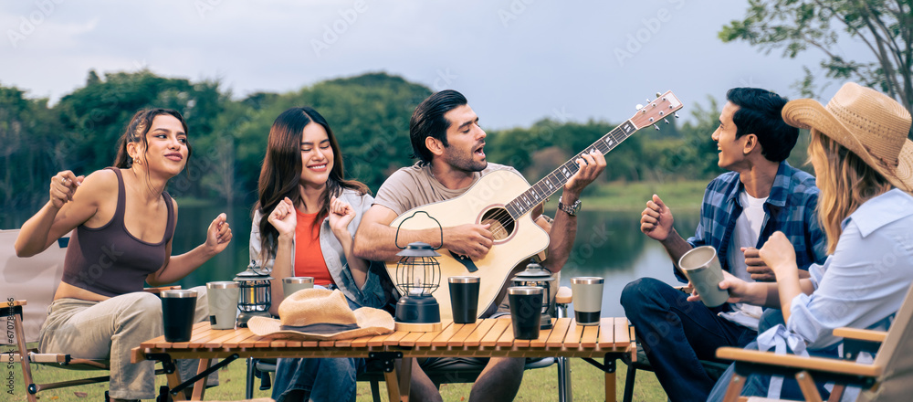 Group of diverse friend having outdoors camping party together in tent.