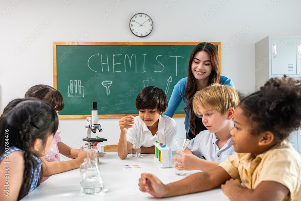 Adorable student learn with teacher in classroom at elementary school. 