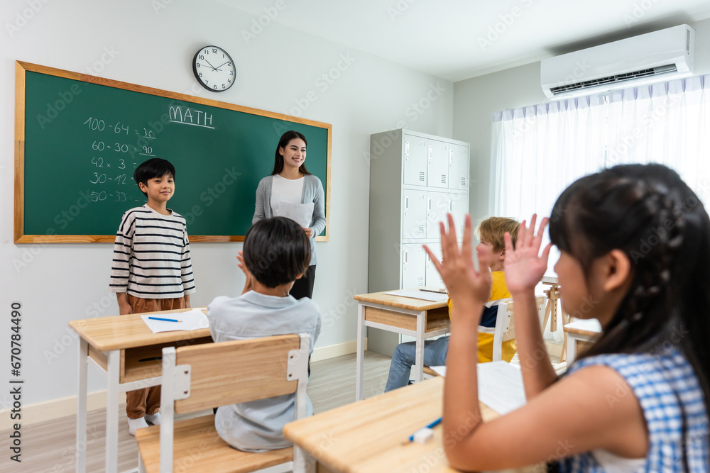 Group of student learn with teacher in classroom at elementary school. 