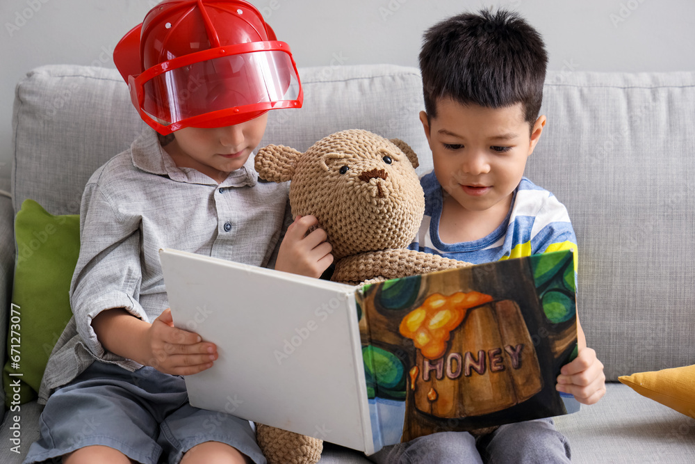 Cute little boys reading story at home