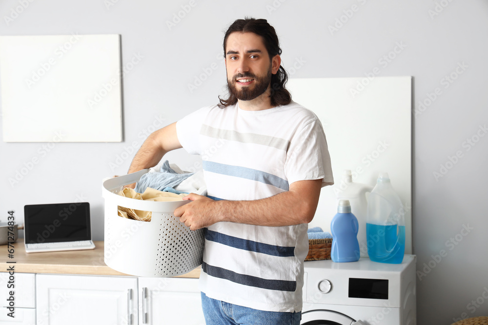 Young man with laundry basket at home