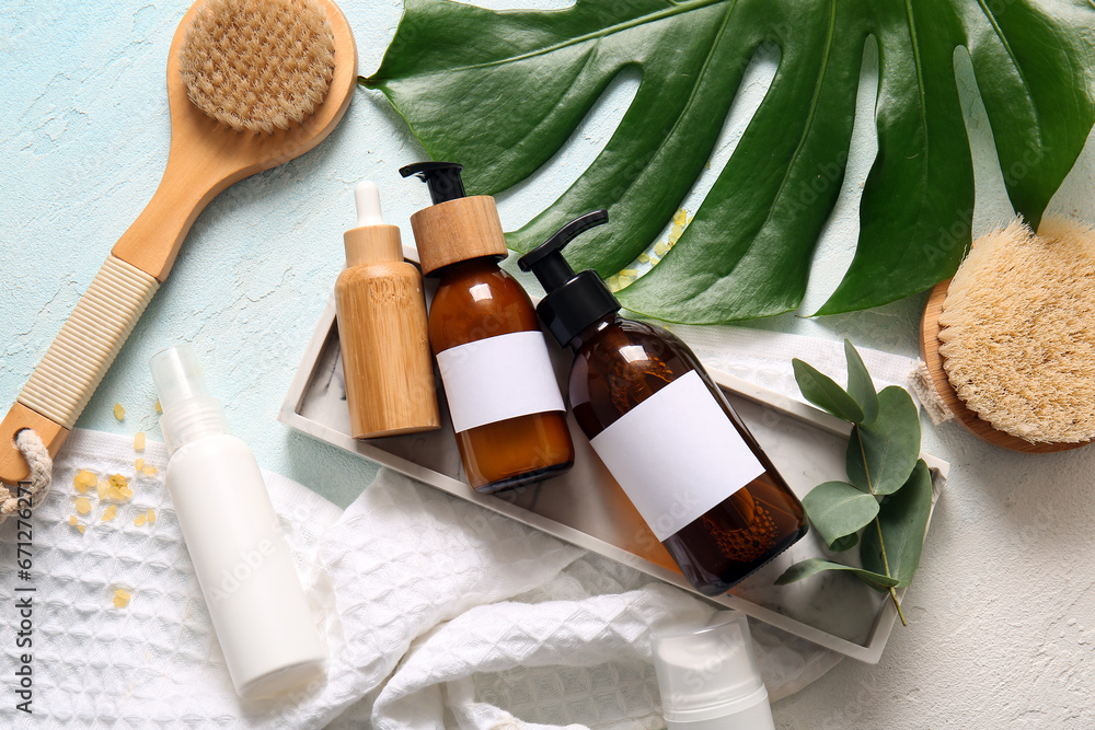 Bottles of shampoo, brushes, and cosmetic products on white background