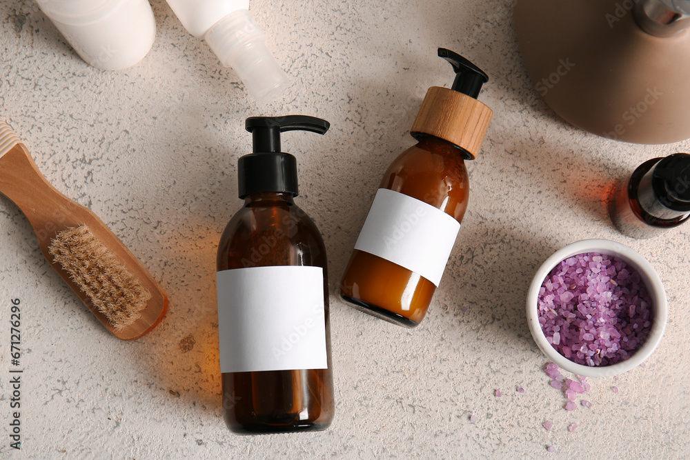 Bottles of shampoo, brush and sea salt on white background