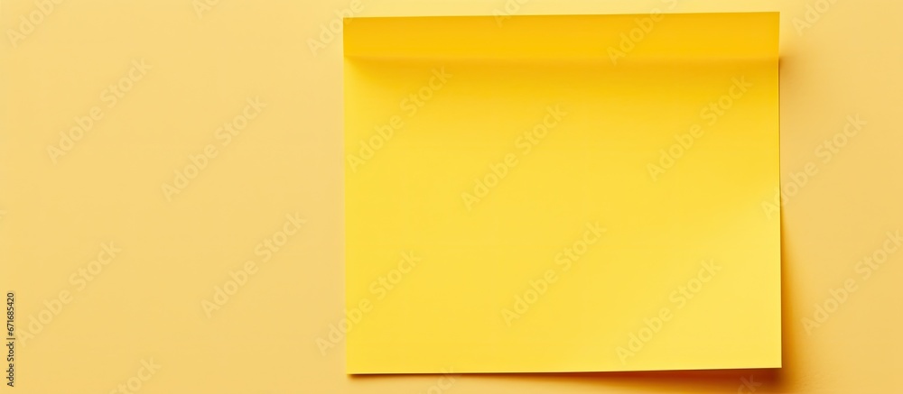 A yellow sticky note is affixed to an empty A4 sheet of paper to serve as a reminder