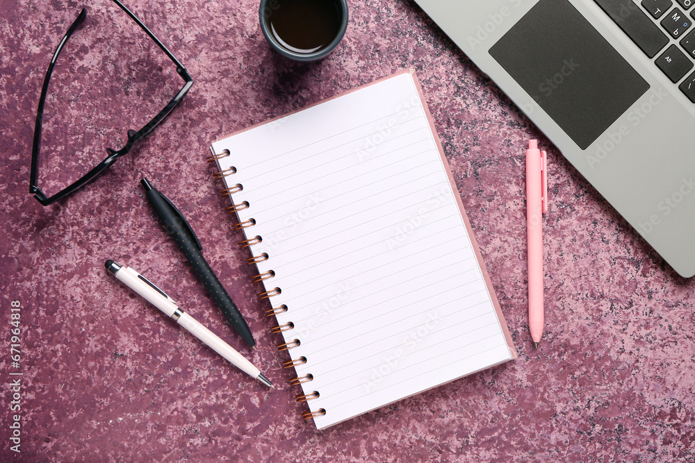 Notebook with eyeglasses and cup of tasty coffee on purple background