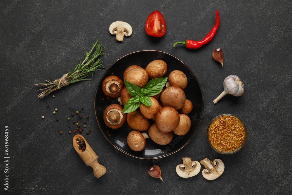 Plate with fresh mushrooms and different spices on black background