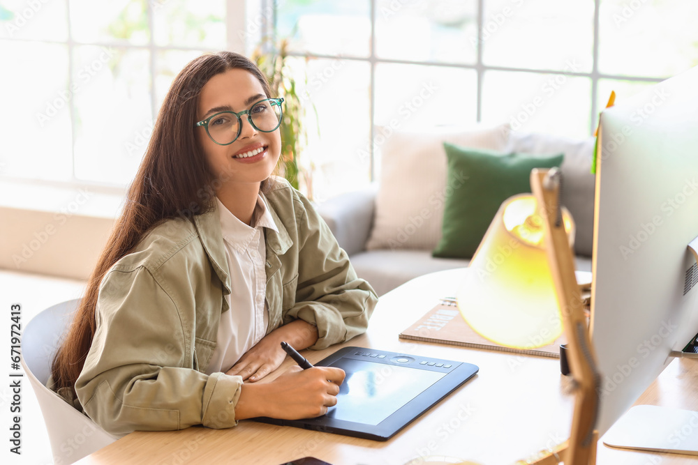 Female interior designer working with graphic tablet at table in office