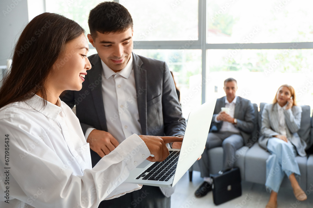 Business people with laptop in office hall