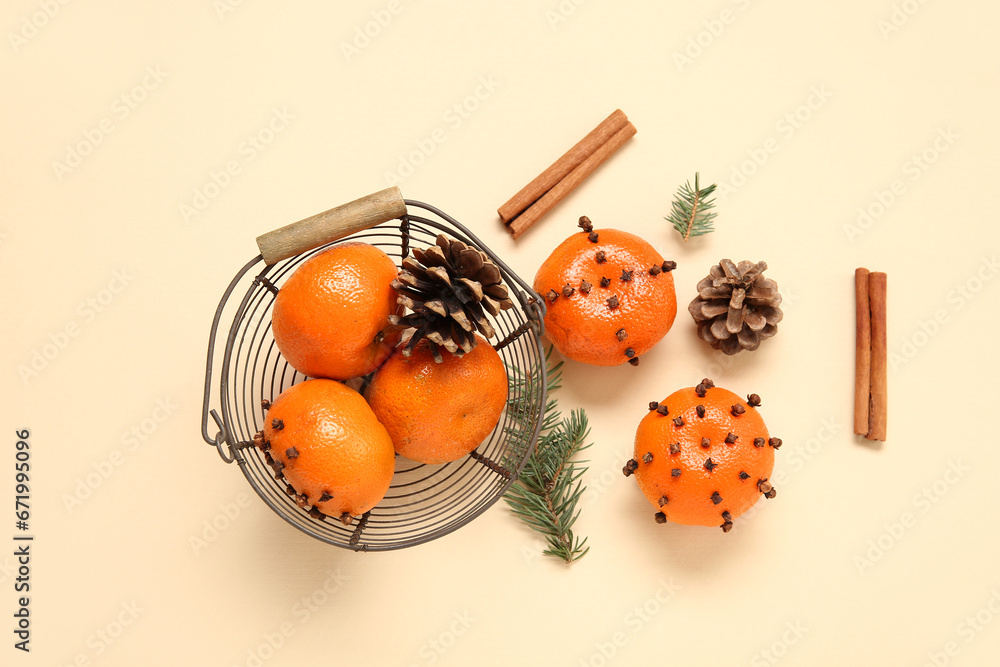 Basket with pomander balls and cinnamon on yellow background