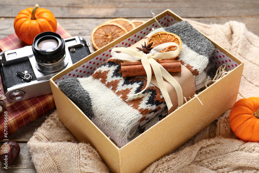 Beautiful composition with warm socks and photo camera on wooden background