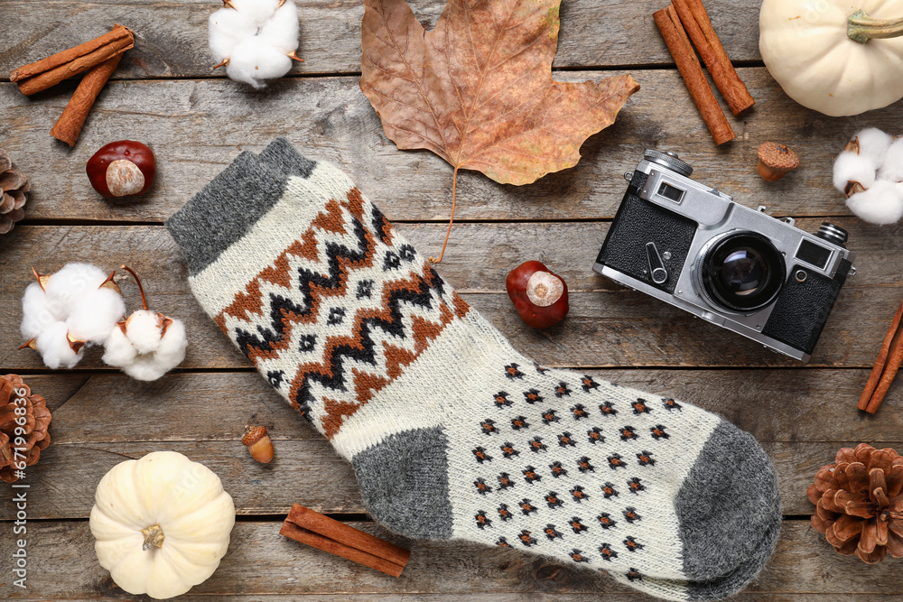 Beautiful composition with warm socks and photo camera on wooden background