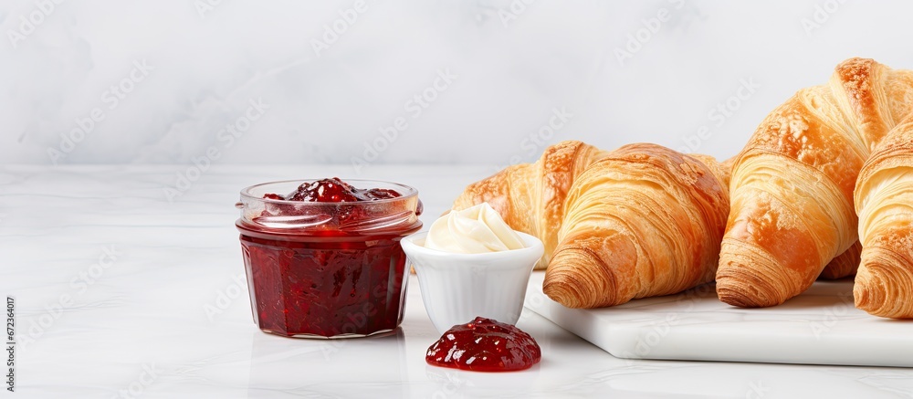 Croissant and jam made at home displayed on a background of marble