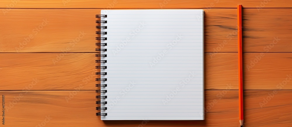 A basic orange colored pencil sits on a collection of empty pages in a school notebook representing the idea of going back to school The arrangement is a model with available room for additi