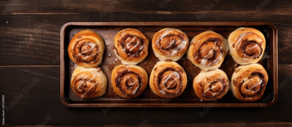 Cream cheese glazed Cinnabon rolls beautifully arranged on a rustic baking sheet The rolls are freshly baked and captured from a top down perspective