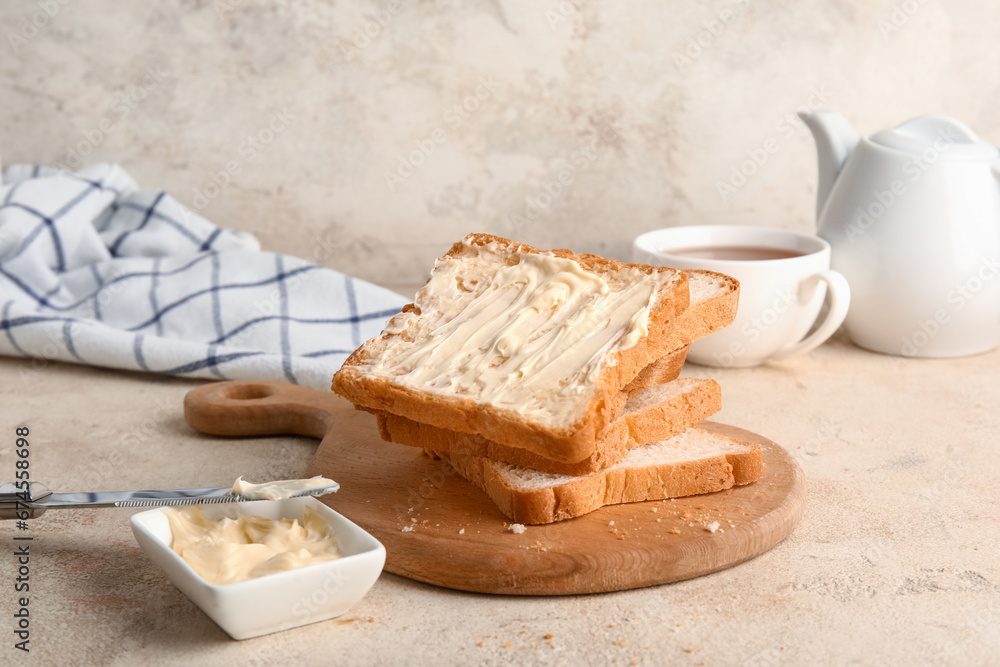 Wooden board of toasts with butter on white background