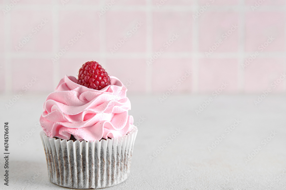 Tasty raspberry cupcake on table