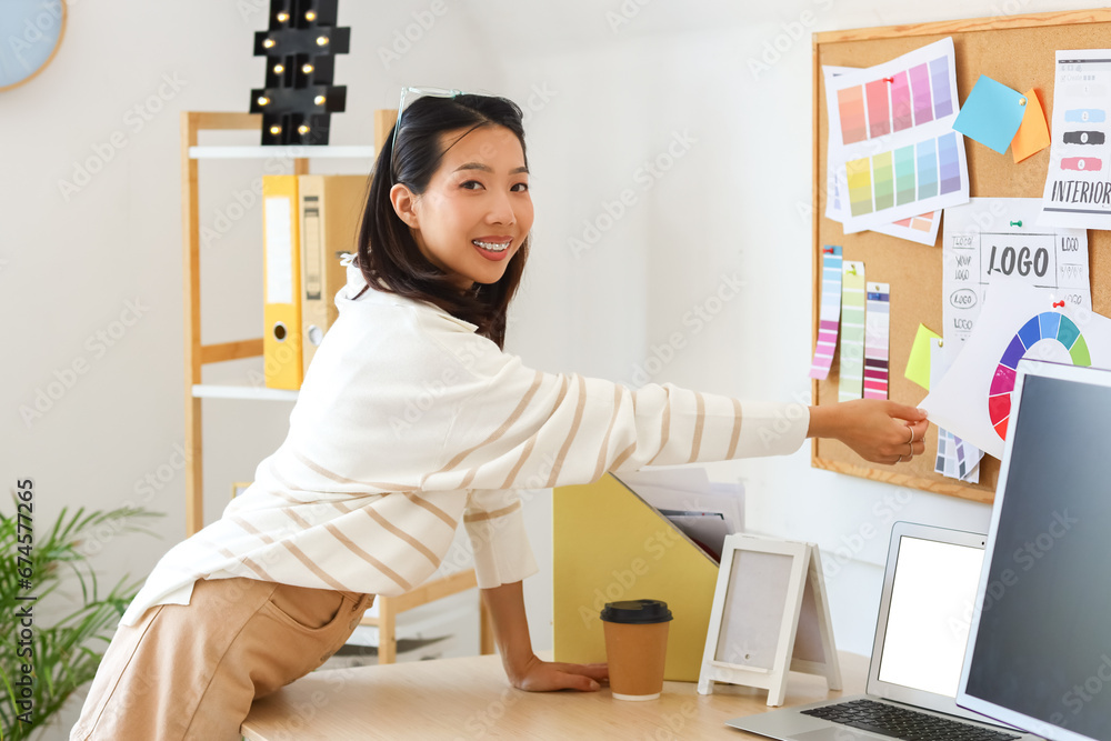 Asian interior designer working with pin board in office