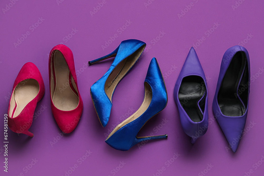 Different stylish high heels on purple background