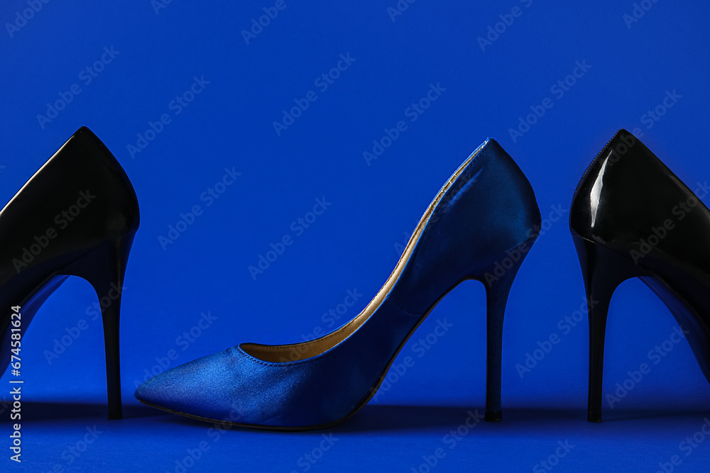 Different stylish high heels on blue background