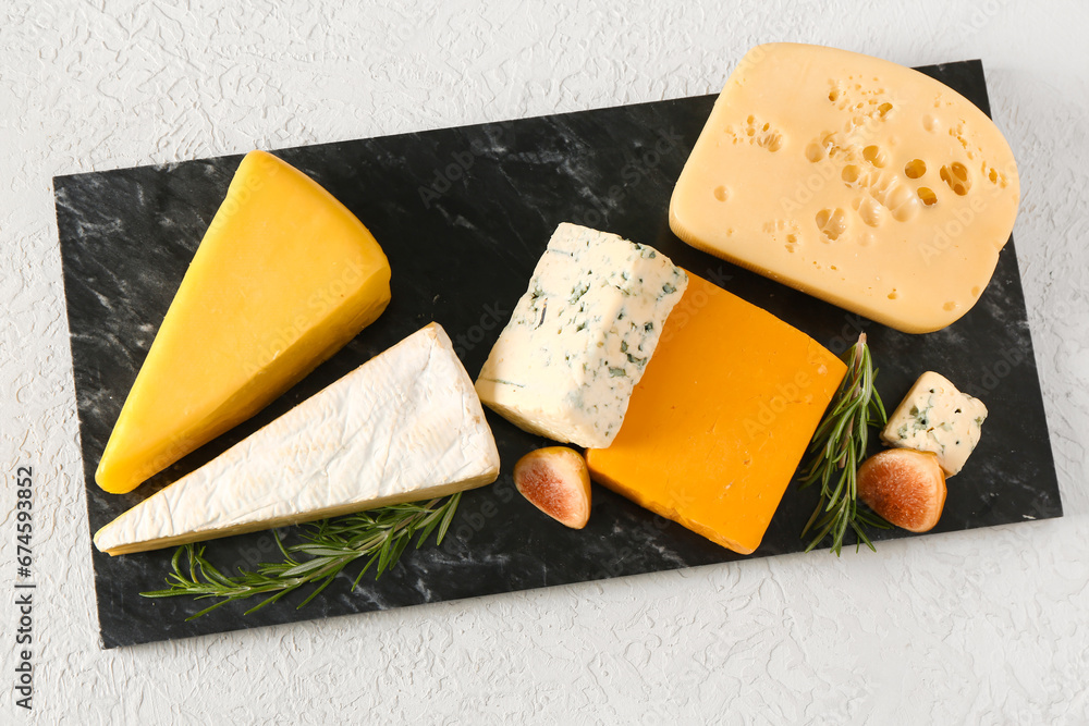 Board with tasty cheese on white background