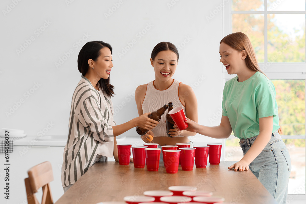 Female friends drinking beer at party