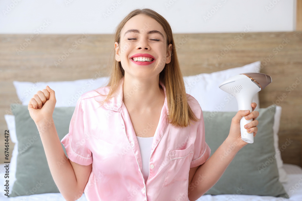 Young woman with modern photoepilator sitting in bedroom at home