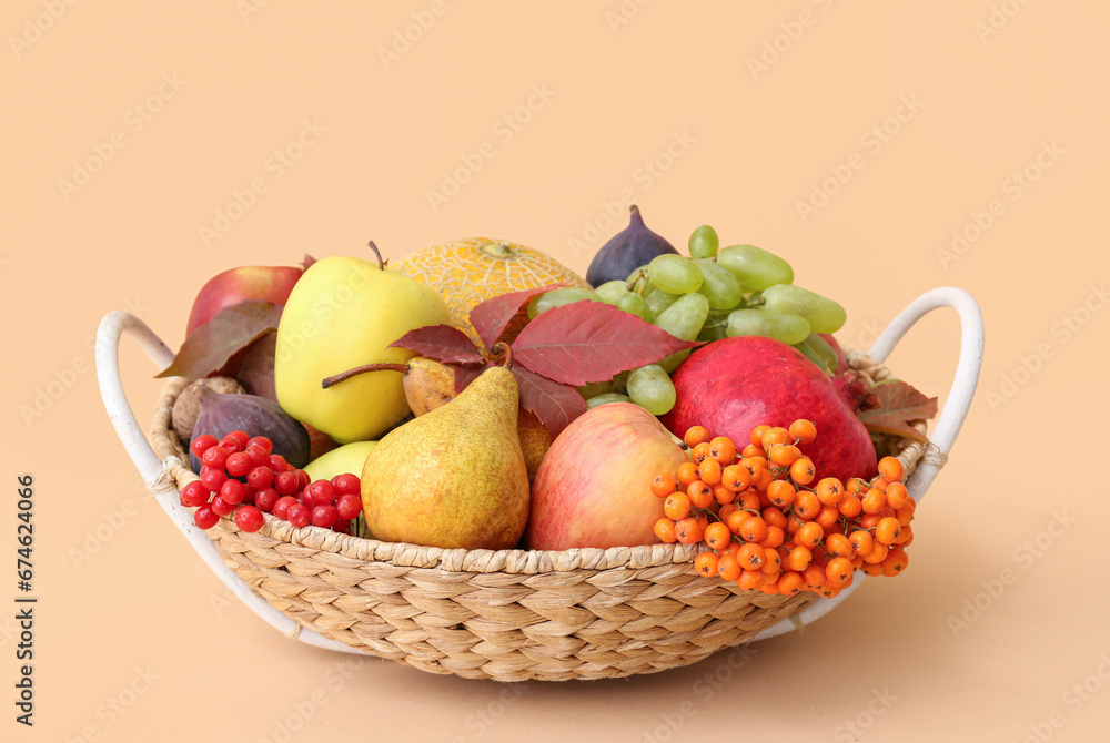 Wicker basket with different fresh fruits on beige background