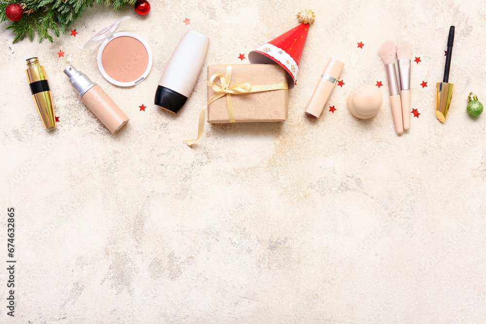 Christmas composition with different makeup products and fir tree branch on light background