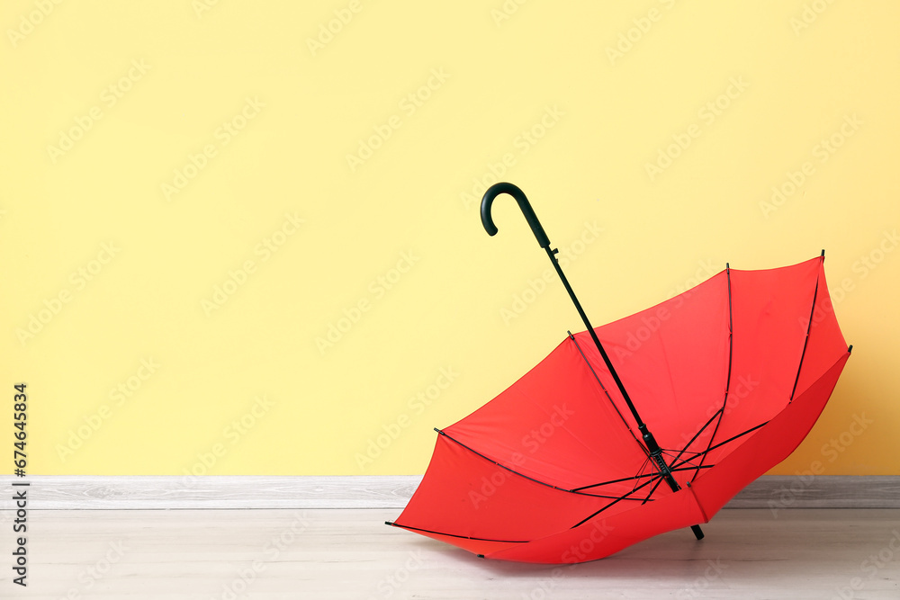 Red stylish umbrella on yellow background