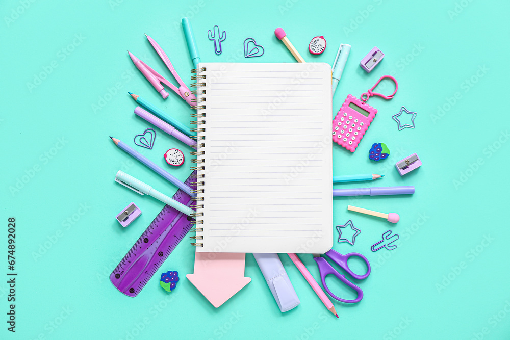 Notebook with different stationery supplies on blue background