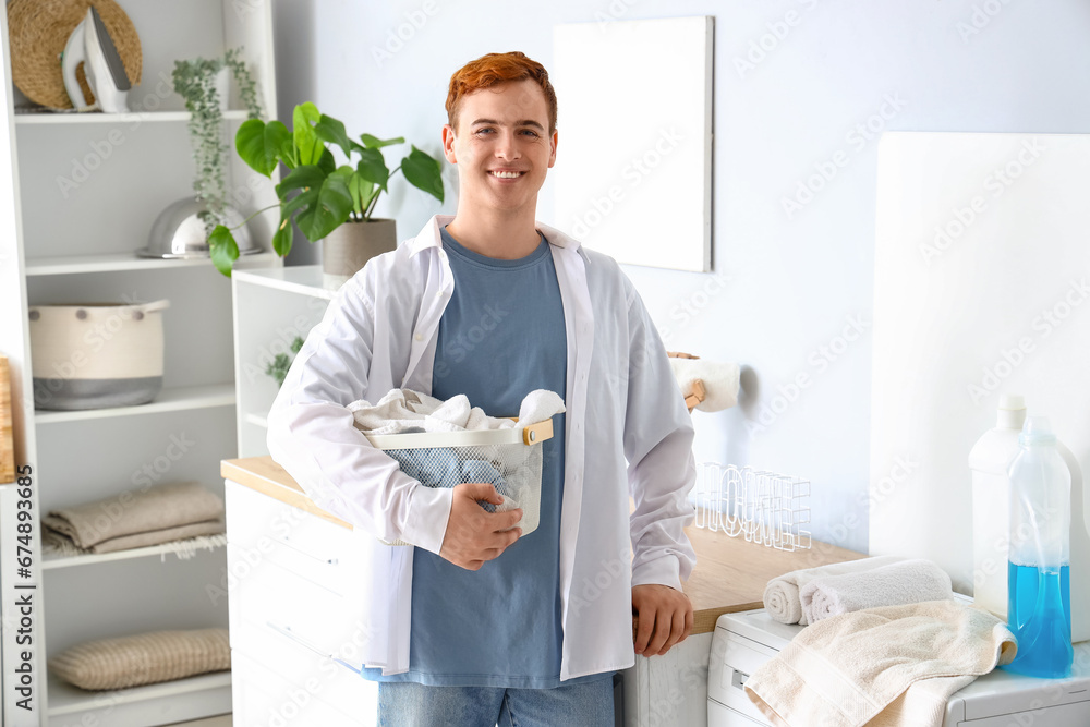 Young man with laundry basket at home