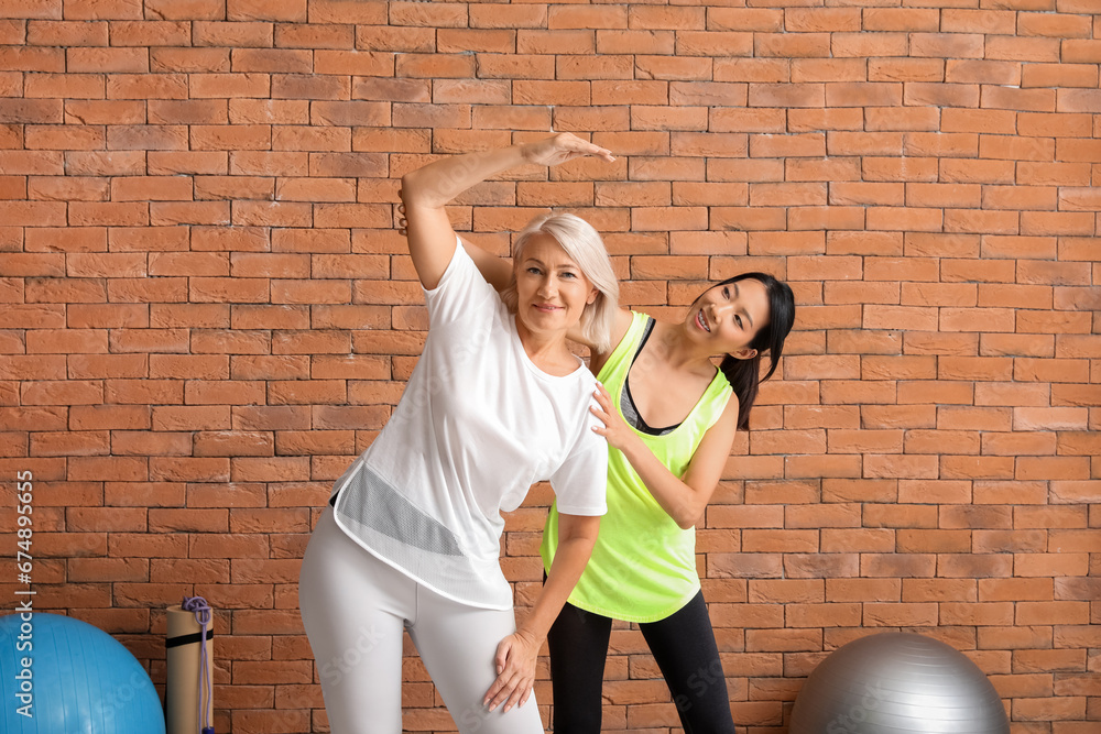 Mature woman training with therapist in rehabilitation center