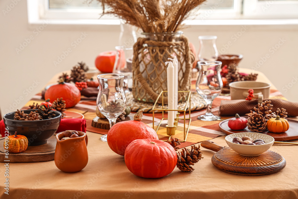 Autumn table setting with pumpkins, pampas grass and pine cones, closeup