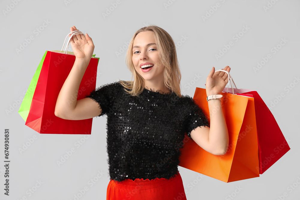 Young woman with shopping bags on white background