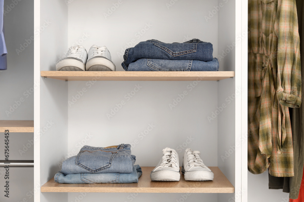 Shelves with stylish shoes and jeans in boutique