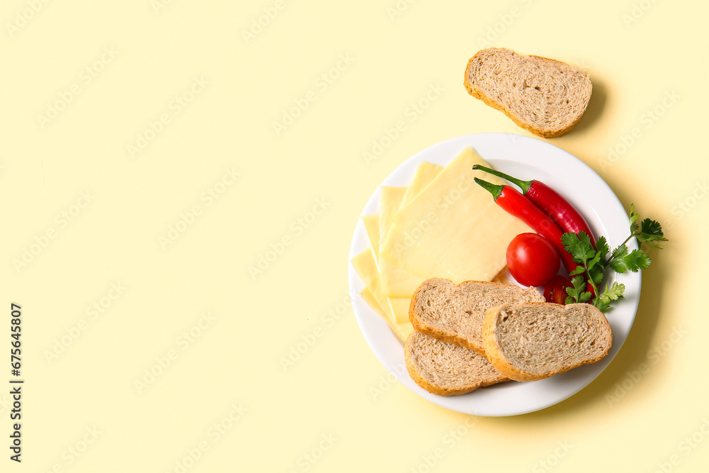 Plate of tasty processed cheese with bread and vegetables on yellow background