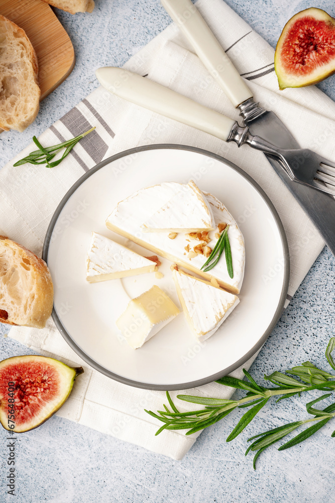 Plate with pieces of tasty Camembert cheese on grey background