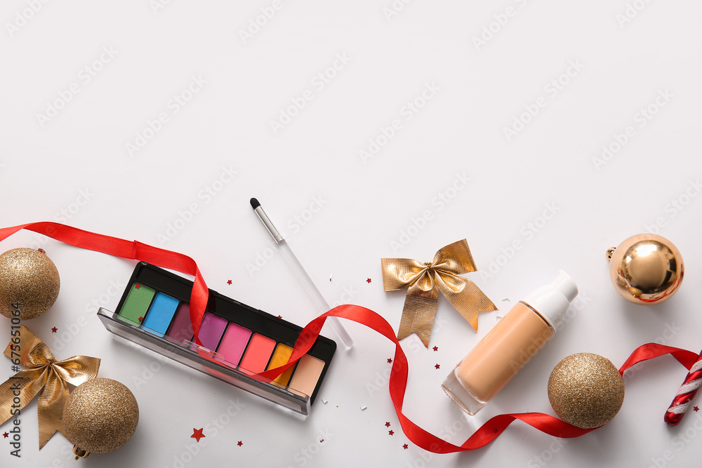 Composition with decorative cosmetics and golden Christmas decor on white background