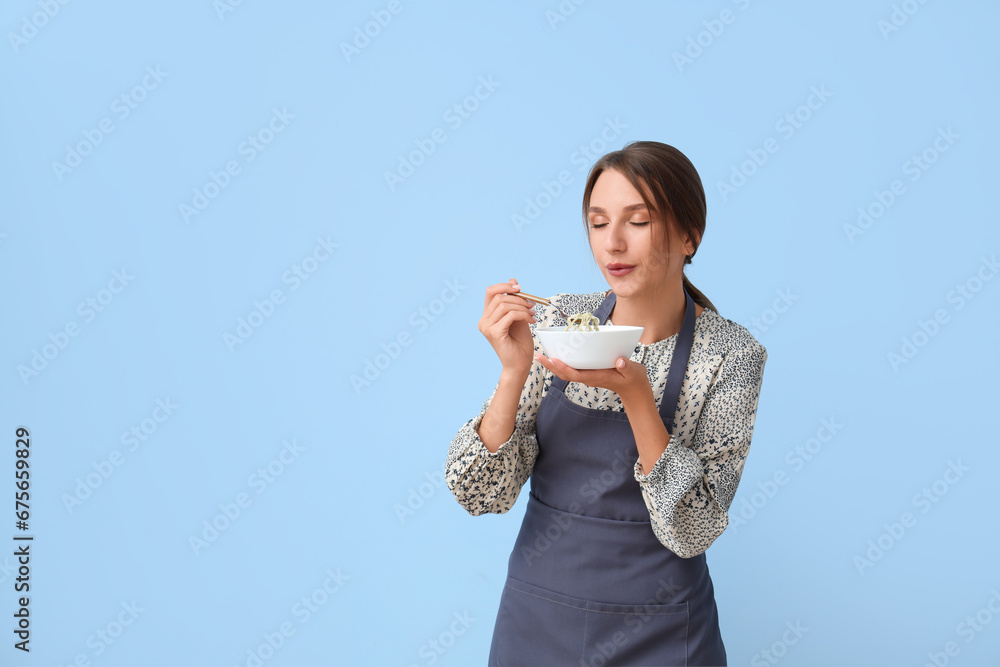 Young woman with chicken soup on blue background