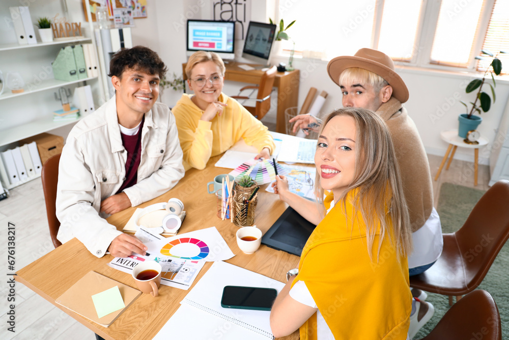 Team of graphic designers working at table in office