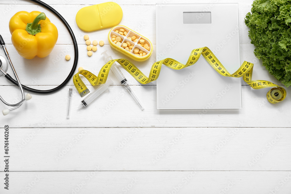 Composition with scales, pills, measuring tape and healthy food on white wooden background