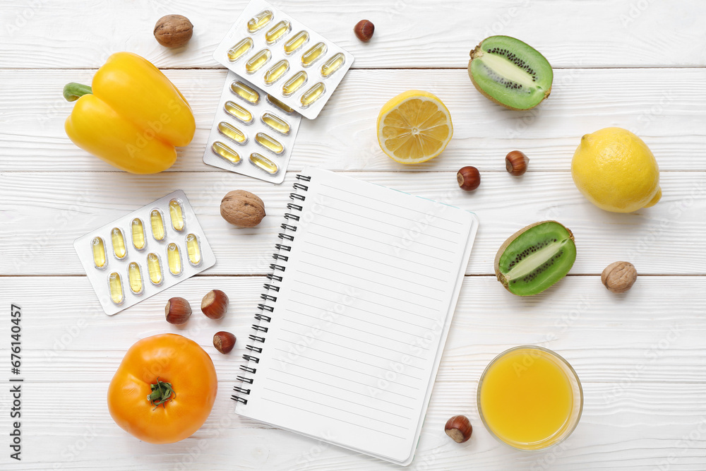 Composition with blank notebook, pills and healthy products on white wooden background