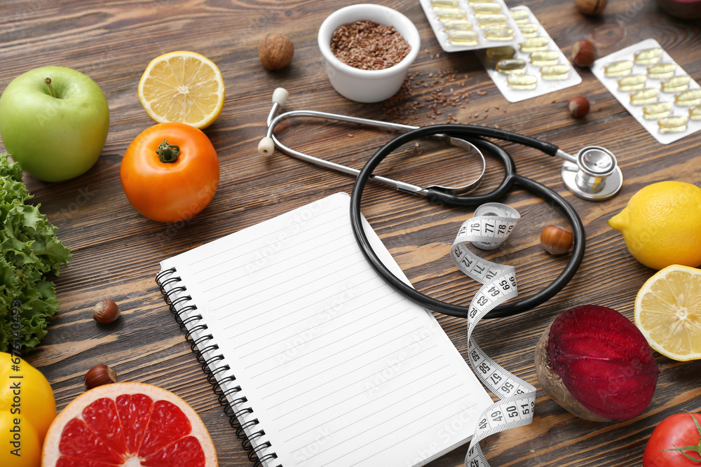 Composition with blank notebook, stethoscope and healthy products on wooden background